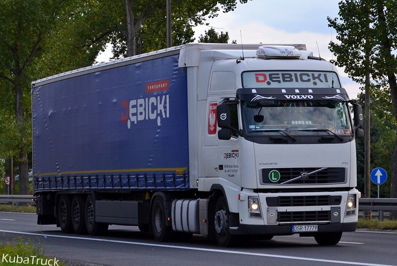 Biały ciągnik Volvo Dębicki z niebieską naczepą, widok z przodu